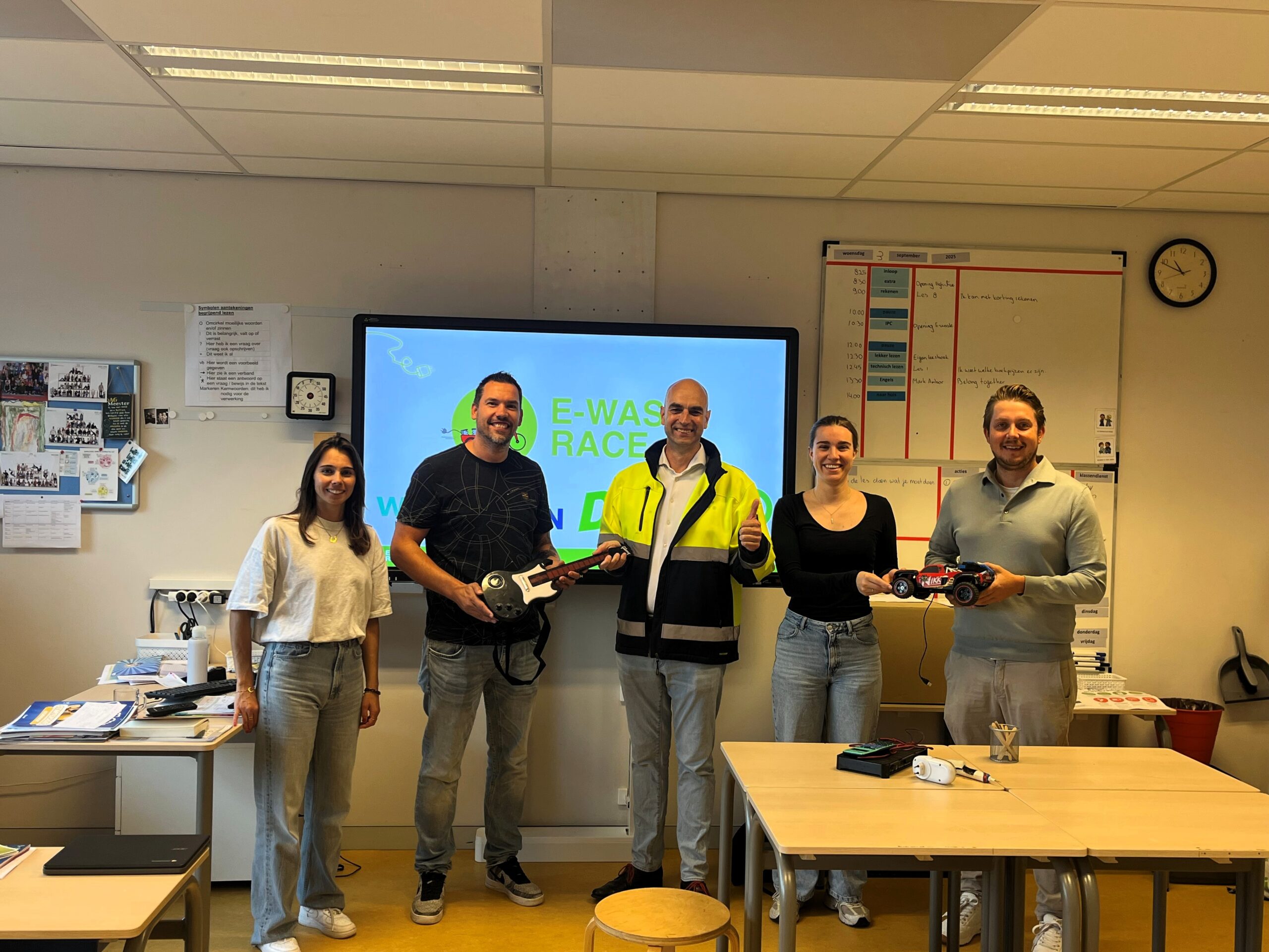 betrokkenen staan in de klas met elektrische apparaten met de  start van e-waste race 