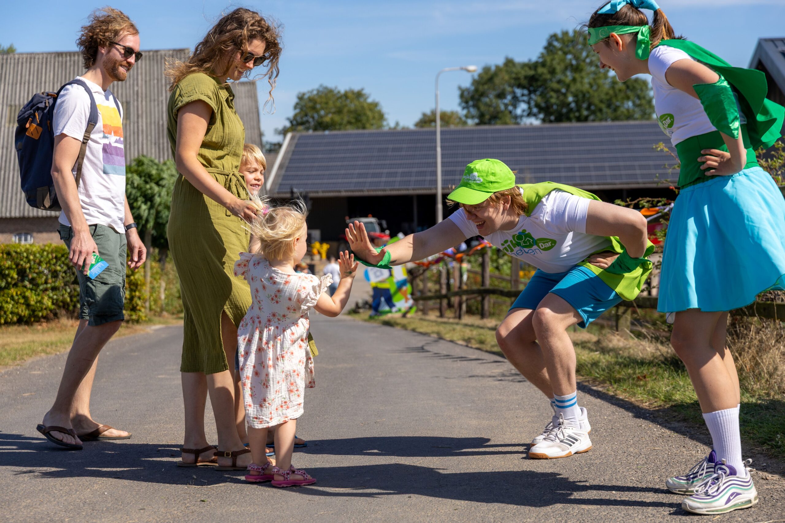 high five van mascottes wijkhelden wendy en wouter aan bezoeker wijkheldendag 