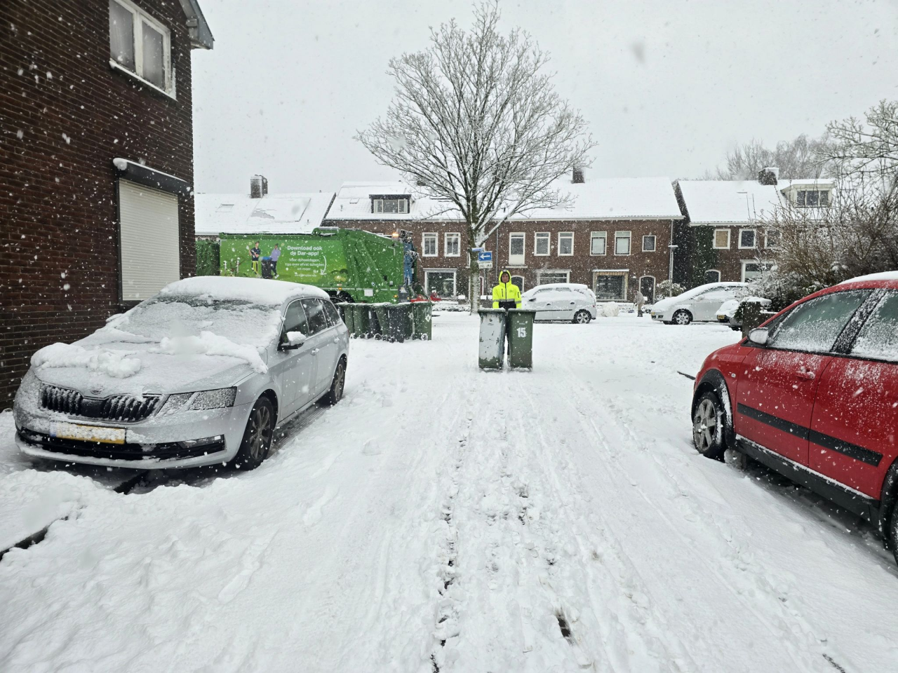 medewerker haalt afval op in de sneeuw 
